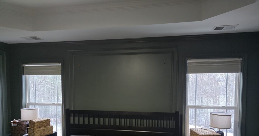 Dark painted bedroom walls with white ceiling and large windows