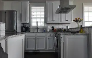 Bright kitchen featuring freshly painted white cabinets, subway tile backsplash, and modern stainless steel appliances.
